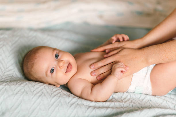 Massage for the baby. Four month old baby smiling doing gymnastics